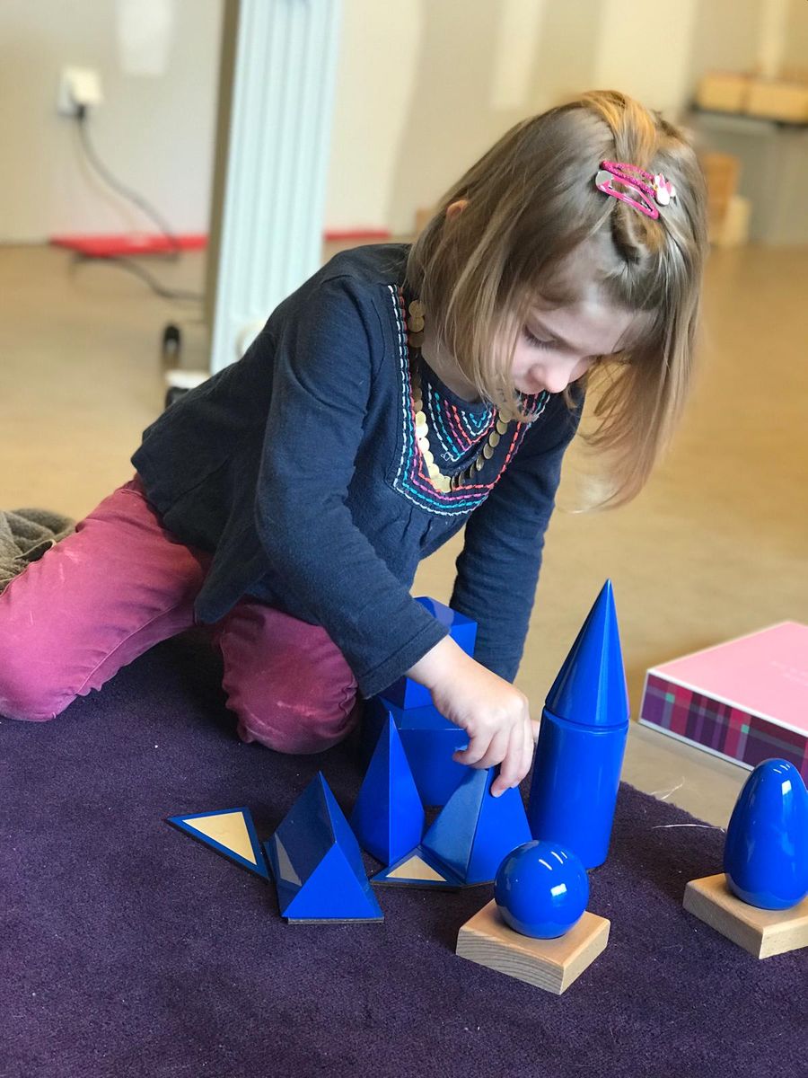Une élève de l'EINA manipulant les solides géométriques Montessori
